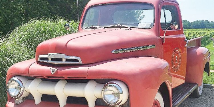 A red truck is parked on the side of the road.