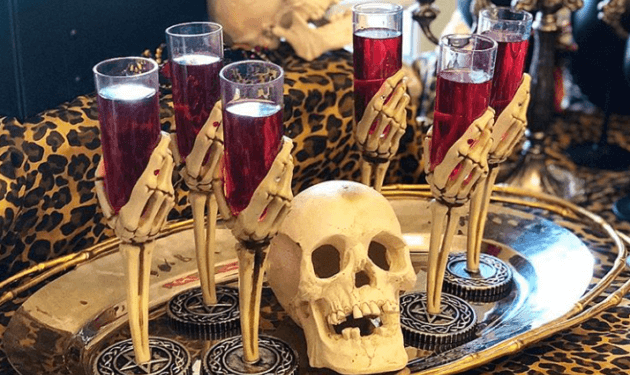 A tray with skulls and glasses of wine on it