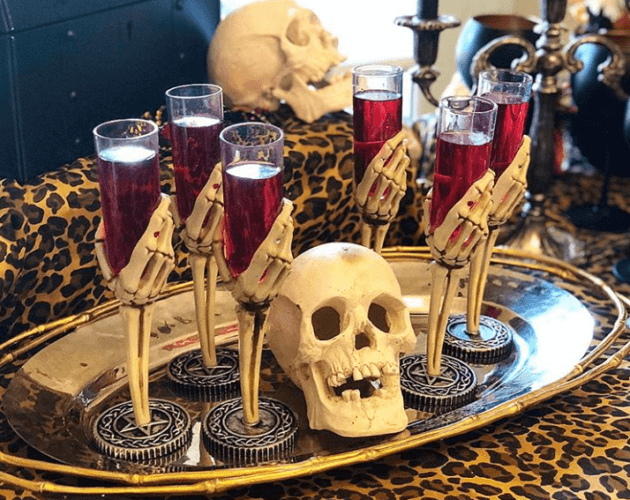 A tray with skulls and glasses of wine on it